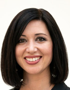 Close-up portrait of a woman with shoulder-length dark hair smiling at the camera.